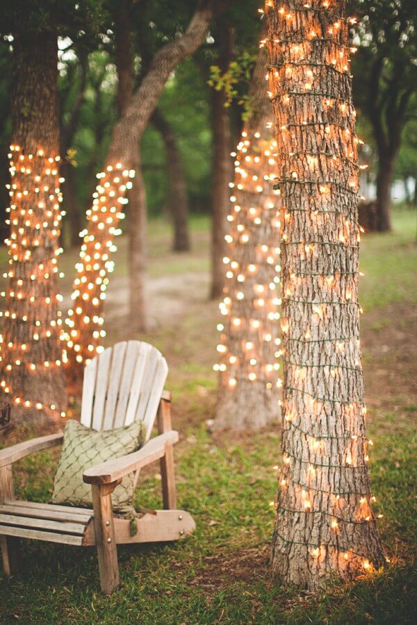 Bäume im Garten mit Lichterketten dekorieren