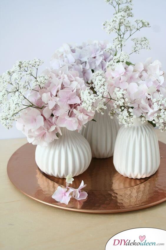 25+ DIY Deko Ideen zu Ostern, weiße Vasen mit Hortensien und Schleierkraut, Tischdeko mit Blumen