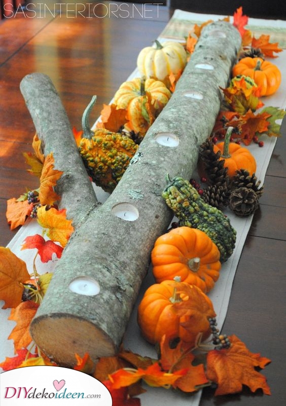 Ein Stamm voller Kürbisse als Herbst-Tischdekoration